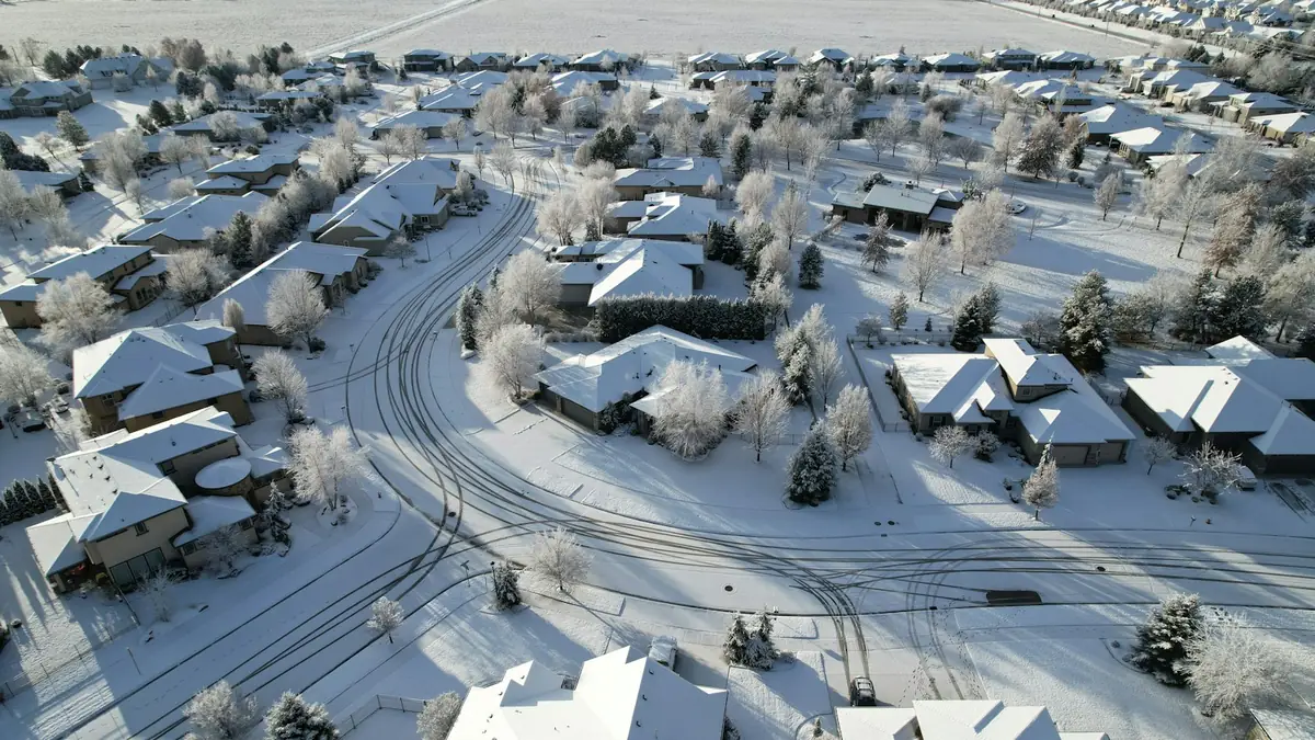 A snowy aerial view of a subdivision of single-story homes - Leak Detection in Caldwell